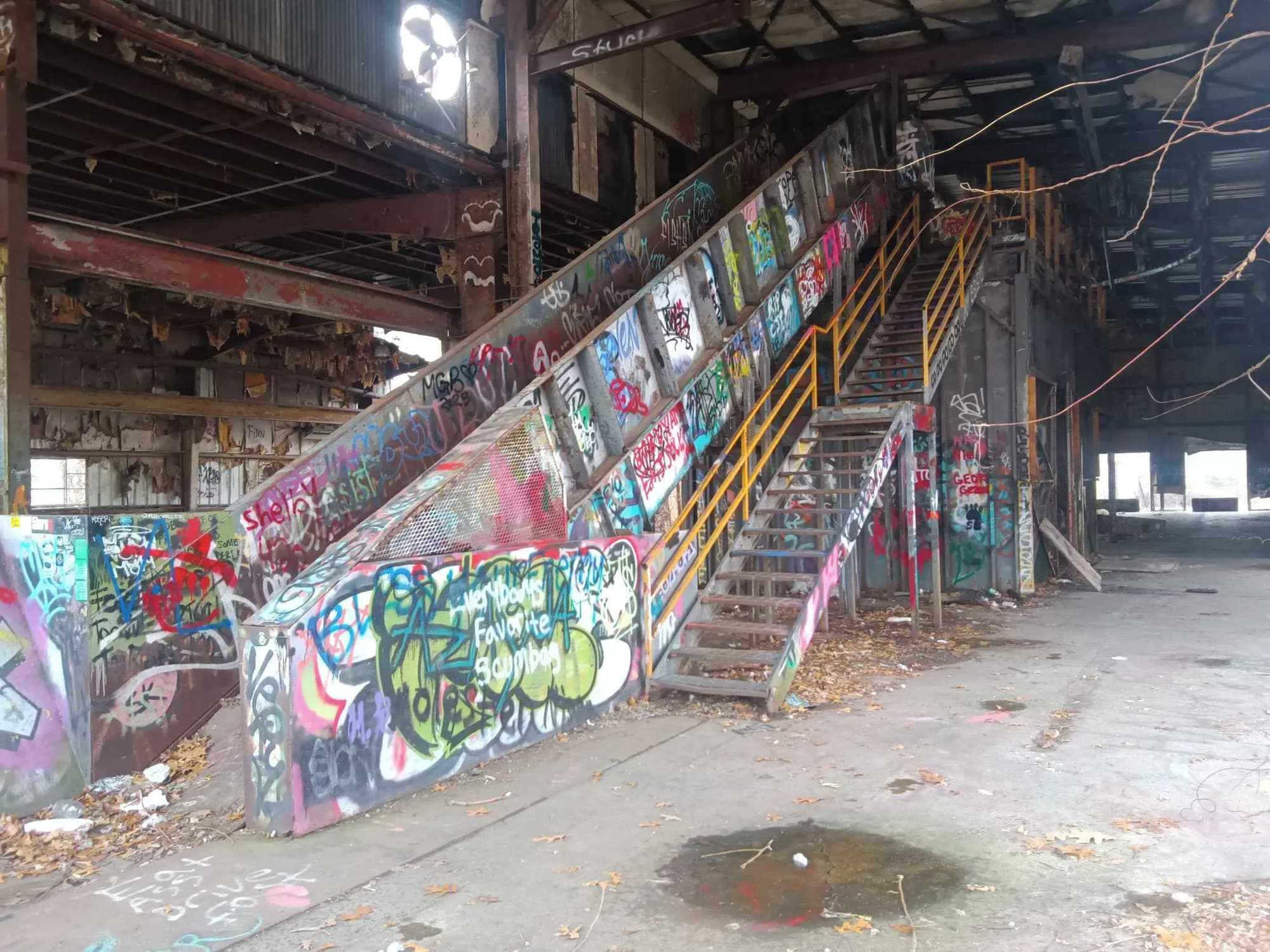 The interior of a vacant industrial building with a steel staircase.